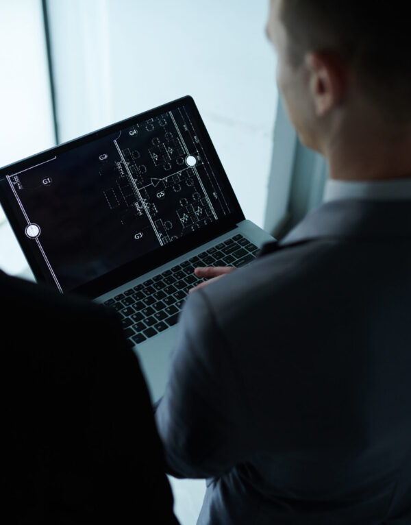 Investors discussing building blueprint on laptop screen at meeting
